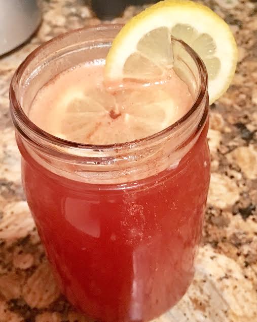 A jar of cinnamon drink accompanied by a lemon slice